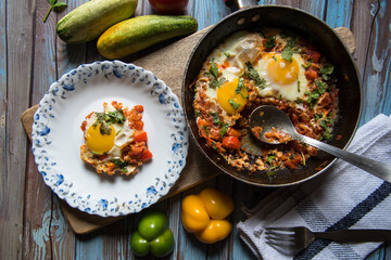Shakshouka, a middle eastern delicacy served on a white plate from a pan