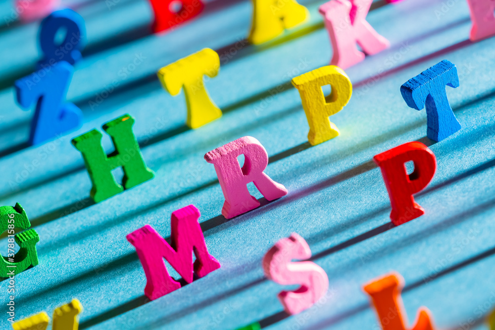Fototapete large multi-colored letters of the english alphabet. the latin letters cast a shadow on the blue tab