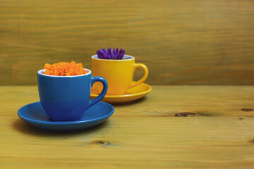 Beautiful flower petals in a cups  on wooden background. 