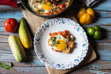 Close up of Shakshuka on a plate with ingredients and condiments
