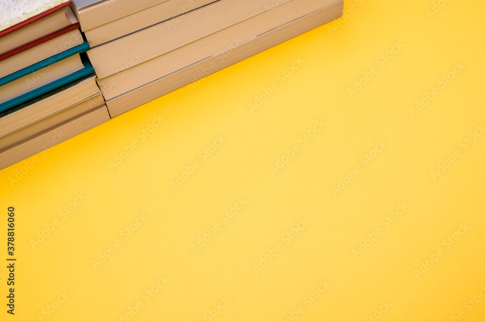 Canvas Prints Books stacked on top of each other  on a yellow background