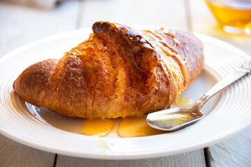 Fresh baked sweet croissants with jam or honey for breakfast