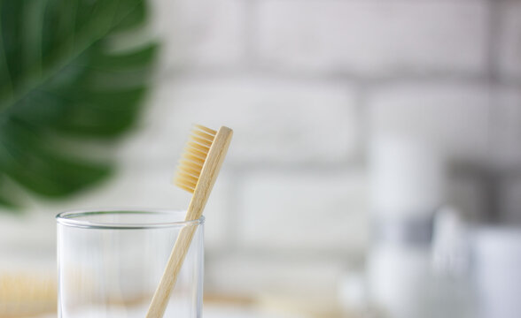 Wooden Toothbrush On A Blurry Bathroom Background. Freshness, Drops Of Water On The Glass.