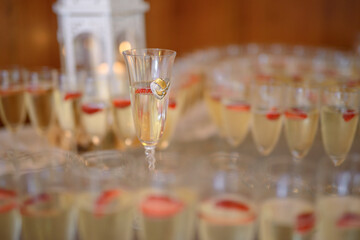 Bottle of cold vodka and wine bottle in bucket with ice and orange juice in jug on table, copy space. Alcohol bottles in ice bucket in restaurant. Wedding party.