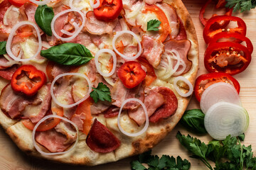 pizza with salami bacon tomatoes peppers onions and Basil herbs