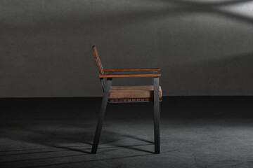 Closeup of a simple modern chair with metallic legs in a room with gray walls