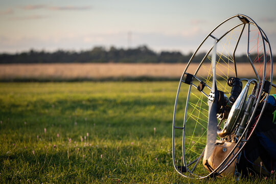 Close-up of an individual parajet backpack with a running gasoline engine and a spinning propeller. Wing flight preparation. Extreme sports. Paralet and small plane.