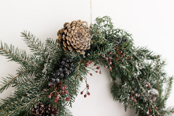 Creative stylish christmas wreath with pine cone and fir branches close up