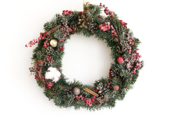 Christmas snowy wreath hanging on white wall in house © sonyachny