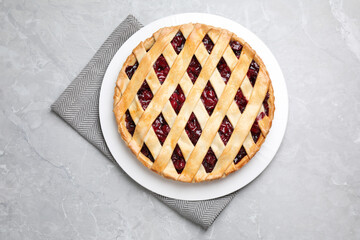 Delicious fresh cherry pie on light grey table, top view