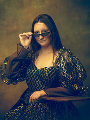 Eyewear black. Young woman as Mona Lisa, La Gioconda isolated on dark green background. Retro style, comparison of eras concept. Beautiful female model like classic historical character, old-fashioned