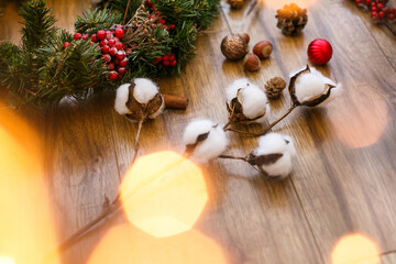 Christmas decorations and Christmas wreath in golden lights on wood