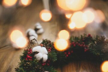 Christmas wreath decorations close up on rustic wood in lights.