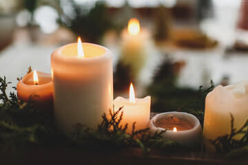 Burning candles on rustic background with christmas wreath, cozy winter advent