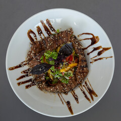 Hot Veal Salad on a white plate with original serving.