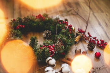Christmas wreath on wooden rustic background in lights