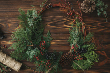 Modern rustic christmas wreath on wooden table flat lay, holiday advent.