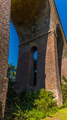 Fototapeta na wymiar A view looking up towards an arch of the Chappel Viaduct near Colchester, UK in the summertime