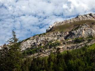 Terrible lifeless rocks, a glacier in the Alps, clouds and fog spread over the peaks of the mountains