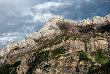 Terrible lifeless rocks, a glacier in the Alps, clouds and fog spread over the peaks of the mountains