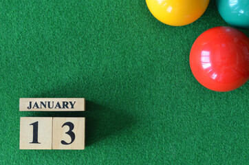January 13, number cube with balls on snooker table, sport background.