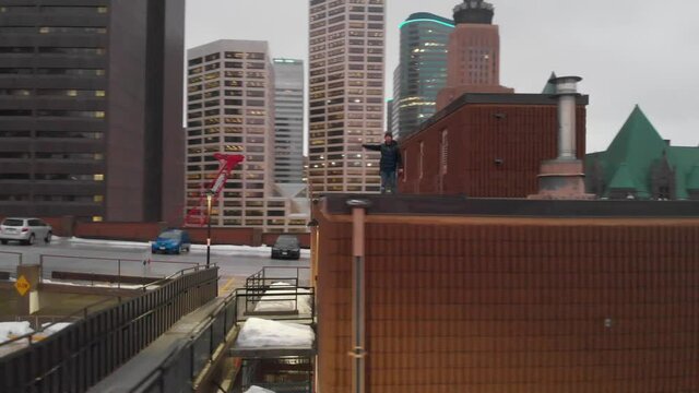 guy walking on a parking lot building rooftop in downtown minnneapolis