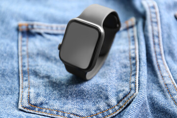 Modern stylish smart watch on jeans, closeup