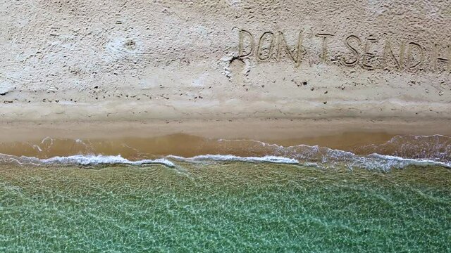 Don't Send Help Message Written On Sand Beach. SOS Message On Sand Beach. Aerial View 