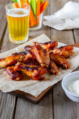 Barbecue chicken wings with carrots, celery and white sauce. Grill. Recipe.