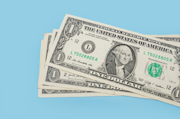 bills of one US dollar on a blue background.
