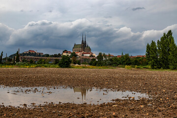 A view of the dominant feature of the city of Brno in the Czech Republic in Europe. Spilberk Castle and Petrov Cathedral are reflected in a pool of water.