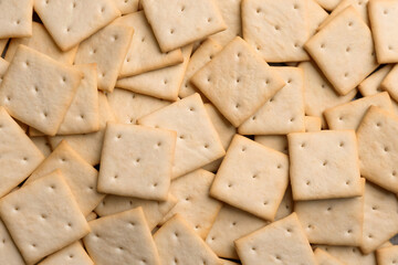 Many delicious crackers as background, top view