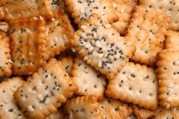 Many delicious crackers as background, top view