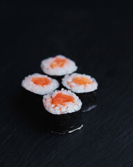 Sushi rolls with salmon on a dark background. Japanese food in the restaurant