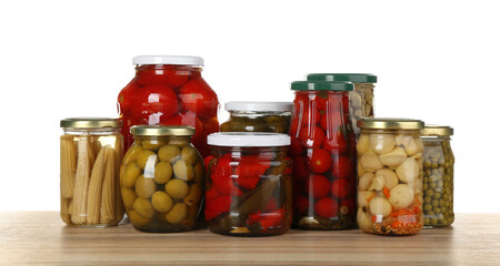 Jars of pickled vegetables on wooden table