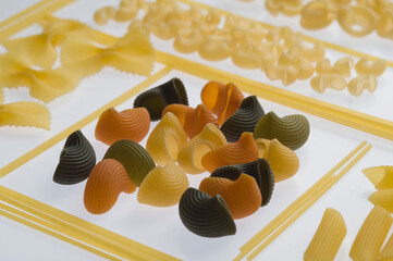 Close-up of various raw pasta on a white background