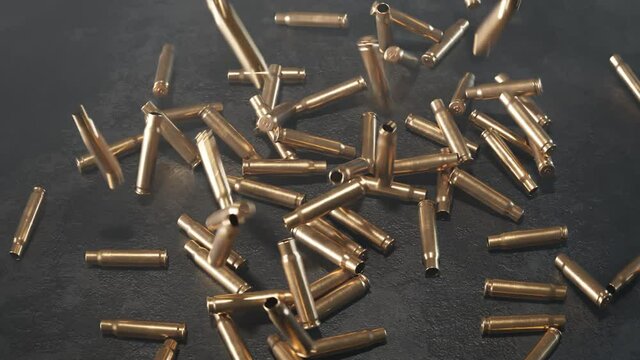 Empty shells falling down on the floor. Gun ammunition. Metal bullets. Ammo.