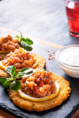 Crispy potato pancakes with salmon and sour cream. Draniki with salmon on a black stone