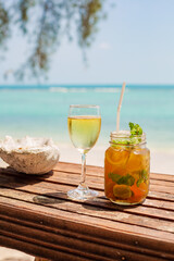 wooden table at a beach bar with a drink in front of turquoise water Ko Samui, thailand