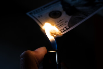 Burning dollar and lighter in hand closeup