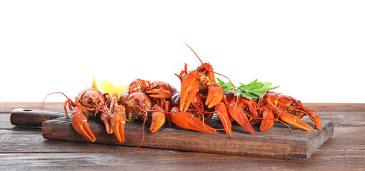Delicious boiled crayfishes on wooden table against white background