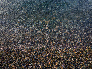 clean sea water beach covered with pebbles black sea. Adler