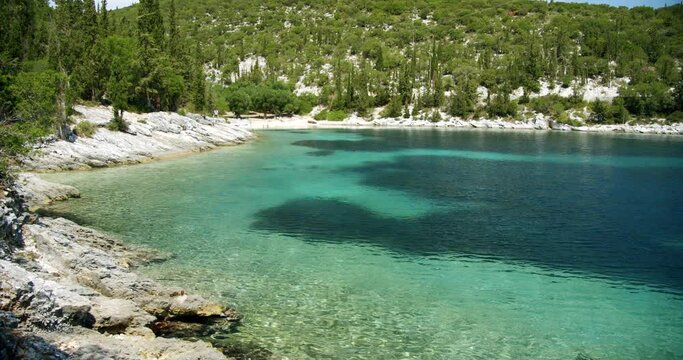 Beautiful landscape with green forest and emerald water lagoon of Foki Fiskardo beach, Kefalonia, Ionian islands, Greece.