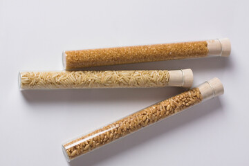 Close-up of brown rice and sugar with wheat in test tubes