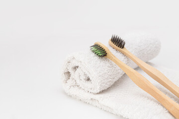 Wooden toothbrushes on white towel with copy space. Ecological material and dental care