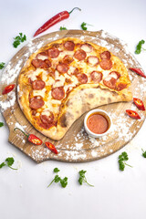 Italian pizza with pepperoni, mozzarella and tomato sauce wooden table