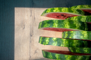 Chopped watermelon. 
Pieces of watermelon on a wooden table. Slices of ripe red watermelon