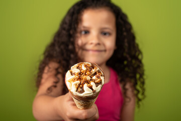 Happy child with ice cream cone with green background, selective focus.