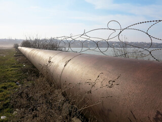 Pipeline. Large iron drainage pipes connect two reservoirs. Large diameter metal pipe for...