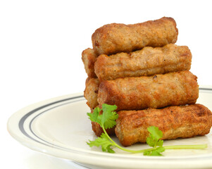 Cooked sausages arranged in plate on white